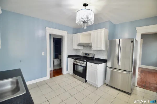a kitchen with stainless steel appliances granite countertop a refrigerator and a stove top oven