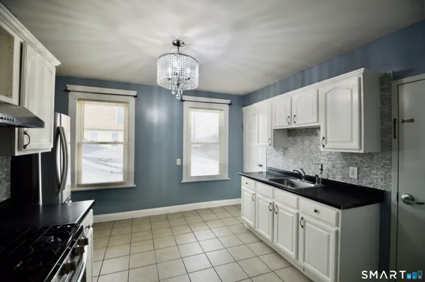 a kitchen with stainless steel appliances granite countertop a sink stove and cabinets