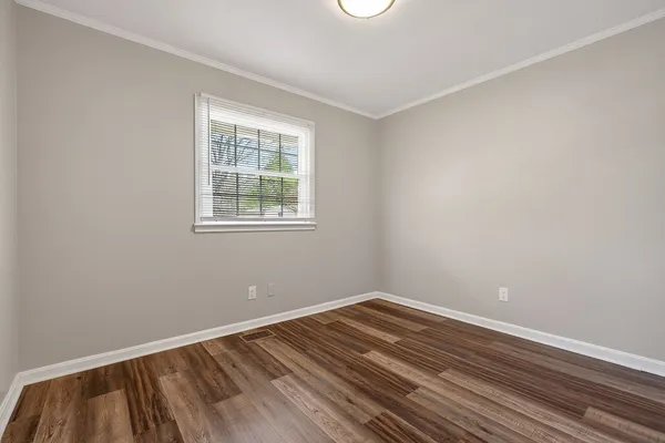a view of a room with wooden floor and window