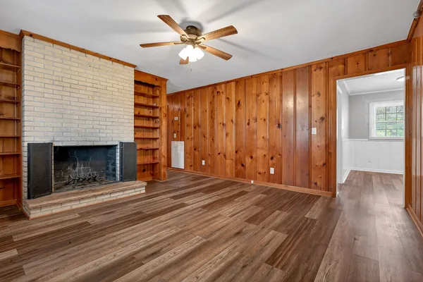 wooden floor fireplace and windows in an empty room