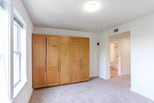 an empty room with windows and closet area