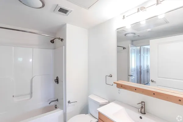 a bathroom with a sink a toilet and shower