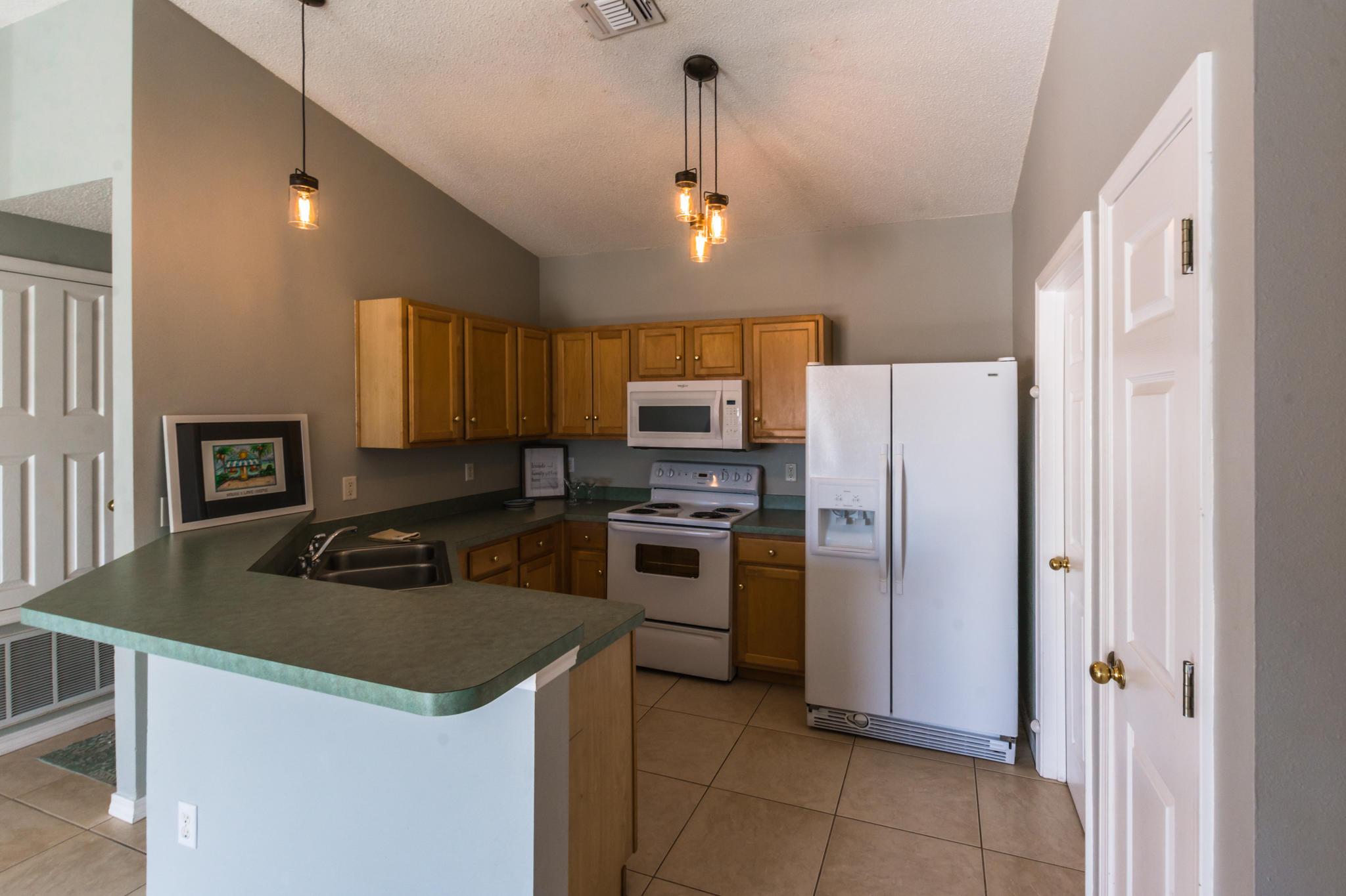 52 Green Island Way Miramar Beach, FL 32550 - Photo 11 of 27 a kitchen with a sink a refrigerator and a stove top oven