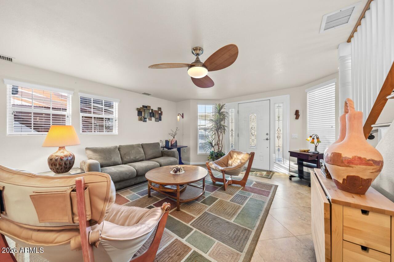 17200 West Bell Road, Unit 1784 Surprise, AZ 85374 - Photo 6 of 25 a living room with furniture a rug and a chandelier