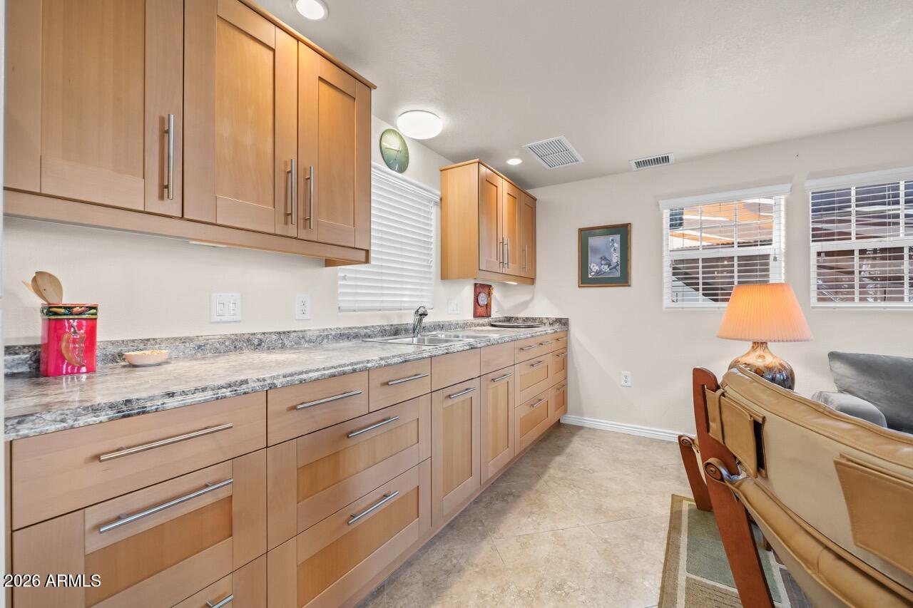 17200 West Bell Road, Unit 1784 Surprise, AZ 85374 - Photo 9 of 25 a kitchen with granite countertop white cabinets and sink