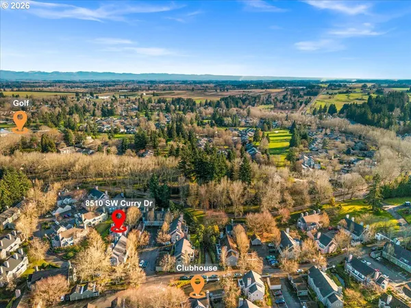an aerial view of a house with swimming pool and large trees
