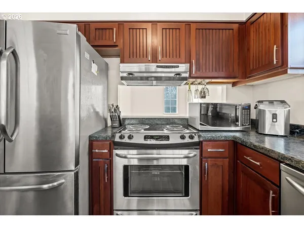 a kitchen with stainless steel appliances granite countertop a stove a refrigerator and a sink