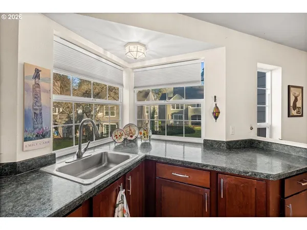 a kitchen with granite countertop a sink and a wooden floor