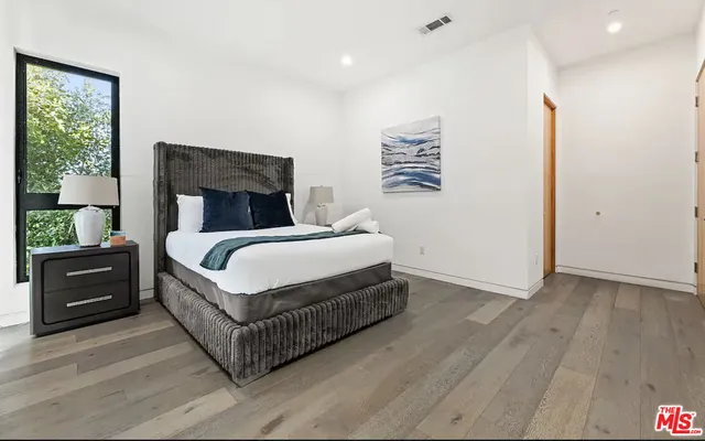 a bedroom with a bed and a night stand