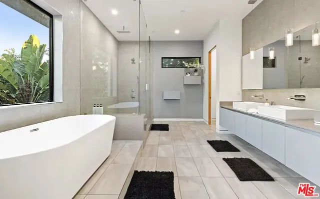 a bathroom with a large tub shower and sink