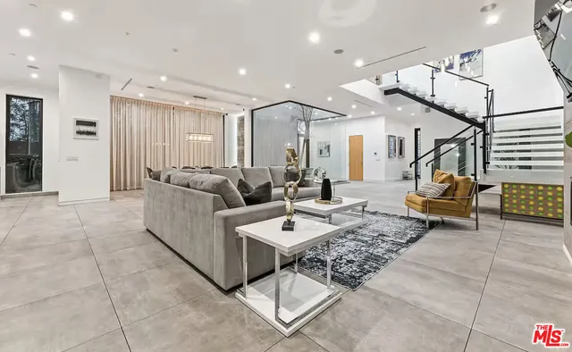 a living room with couches and glass table with wooden floor