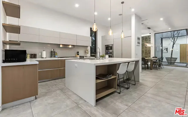 a kitchen with a sink a counter space appliances and cabinets