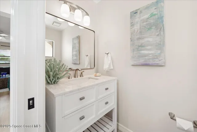a bathroom with a sink vanity granite tub shower and a mirror