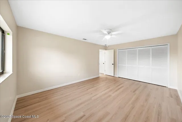 an empty room with wooden floor and window