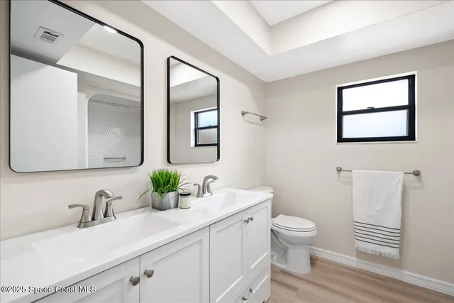 a view of a hallway with wooden floor and windows