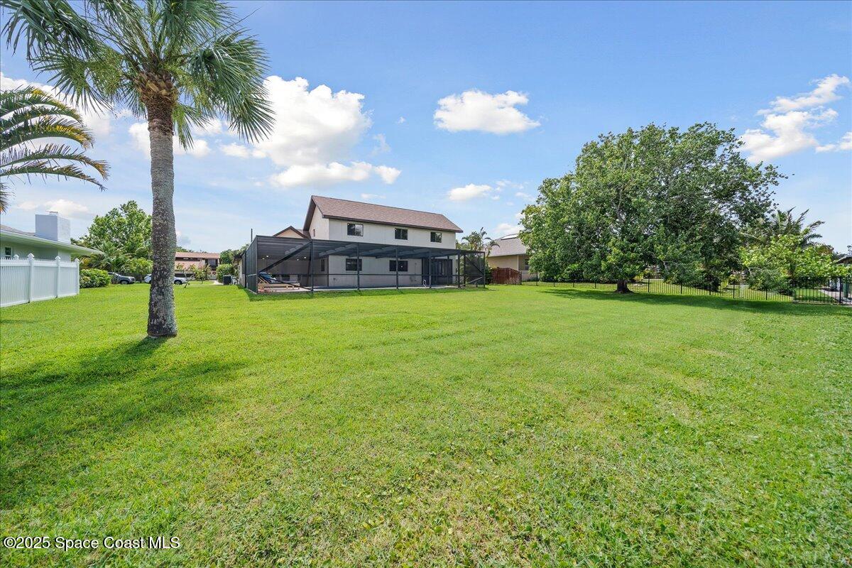6315 Anchor Lane Rockledge, FL 32955 - Photo 38 of 52 a view of a house with a big yard and palm trees
