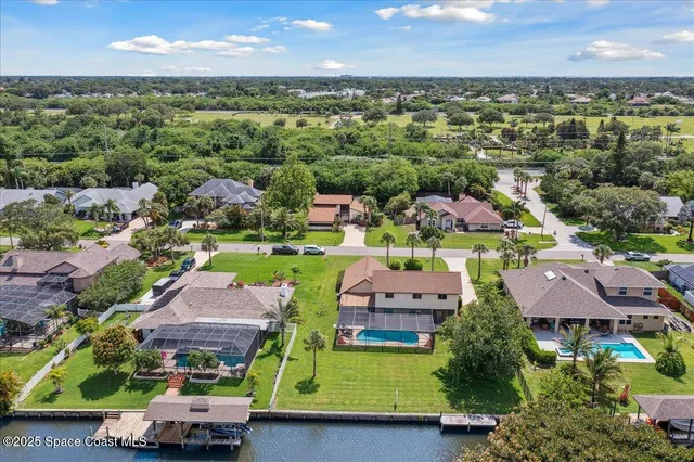 an aerial view of residential houses with outdoor space and river