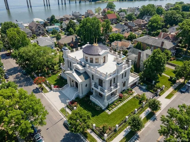 an aerial view of a house with a garden and lake view
