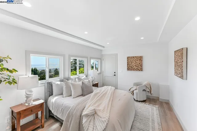 a view of a bedroom with a bed and wooden floor