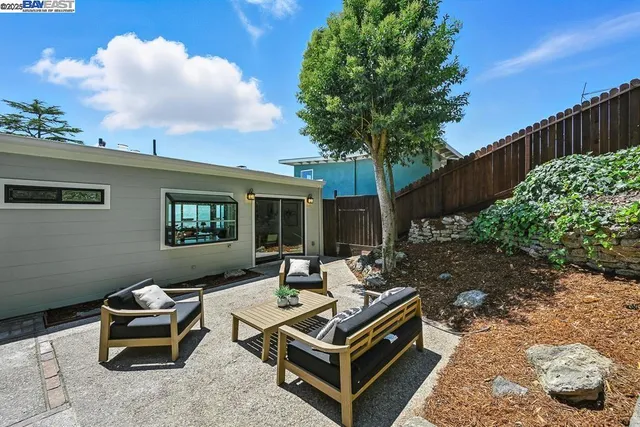 a roof deck with table and chairs and potted plants