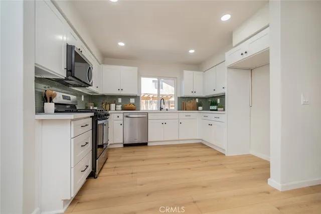 a kitchen with stainless steel appliances granite countertop a sink and cabinets
