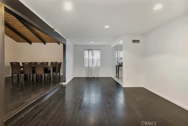 an empty room with wooden floor and furniture