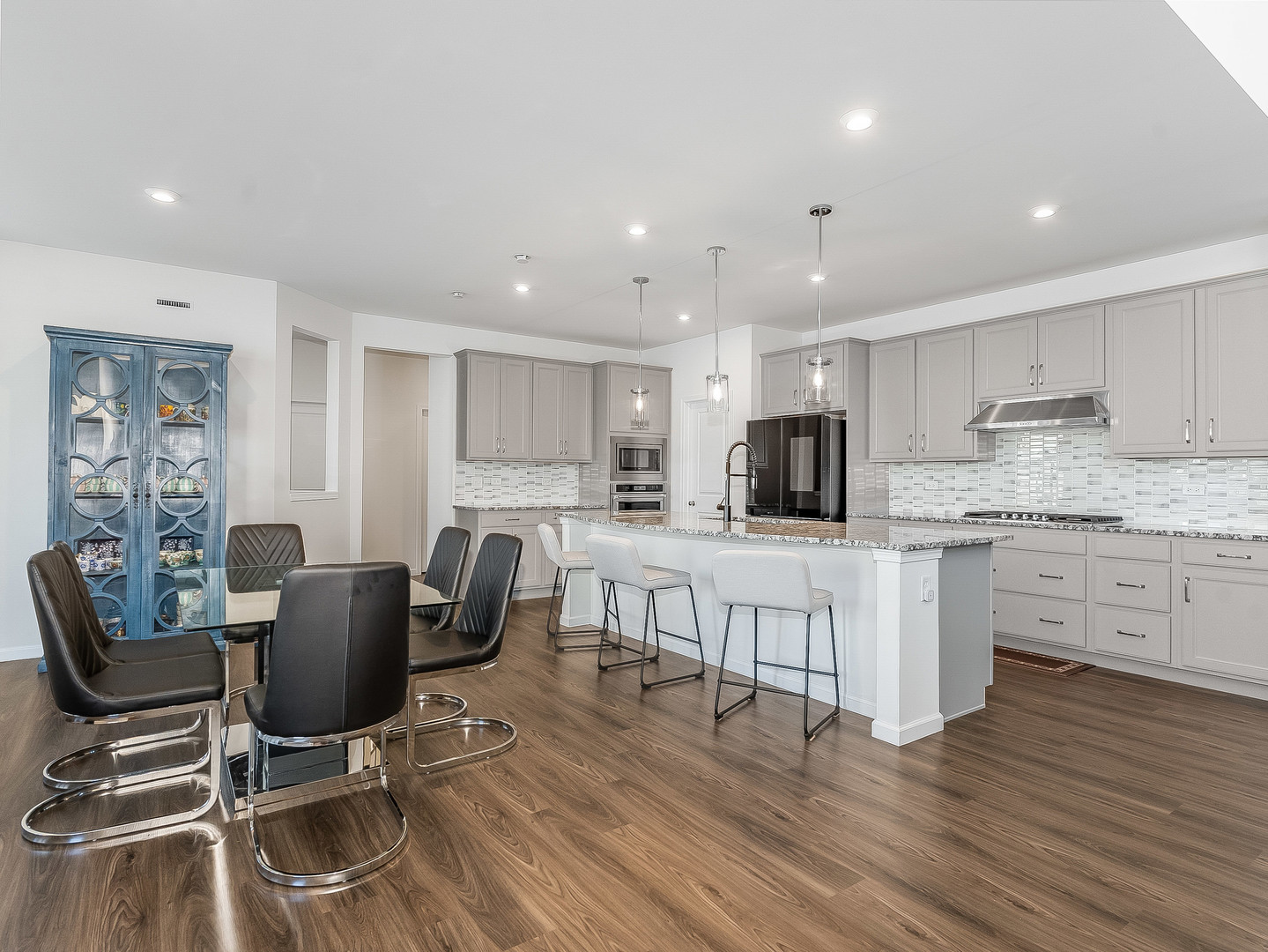 2552 Weatherbee Lane Naperville, IL 60563 - Photo 7 of 43 a kitchen with kitchen island granite countertop a dining table chairs refrigerator and cabinets