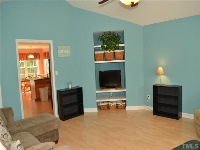 4212 Archibald Way Raleigh, NC 27616 - Photo 2 of 21 Living room features built in shelves, security system (needs to be activated) laminate floors. Home is painted in beautiful beach tones. The living room is a bluish color which goes with any decor. Features Cathedral ceiling large double windows.