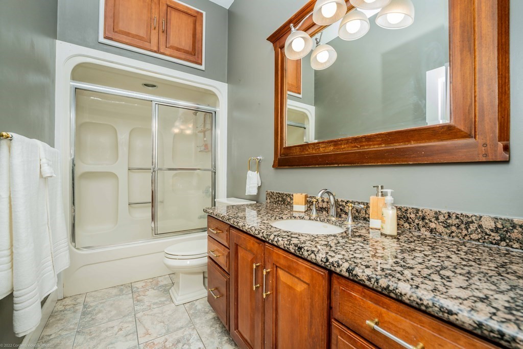 93 Narrows Road Assonet, MA 02702 - Photo 31 of 42 a bathroom with a granite countertop sink a toilet and a mirror