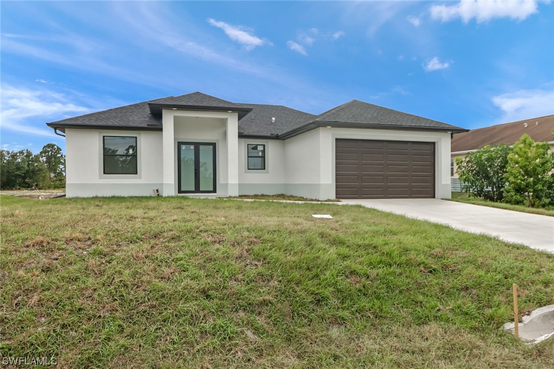 a front view of a house with yard and garage