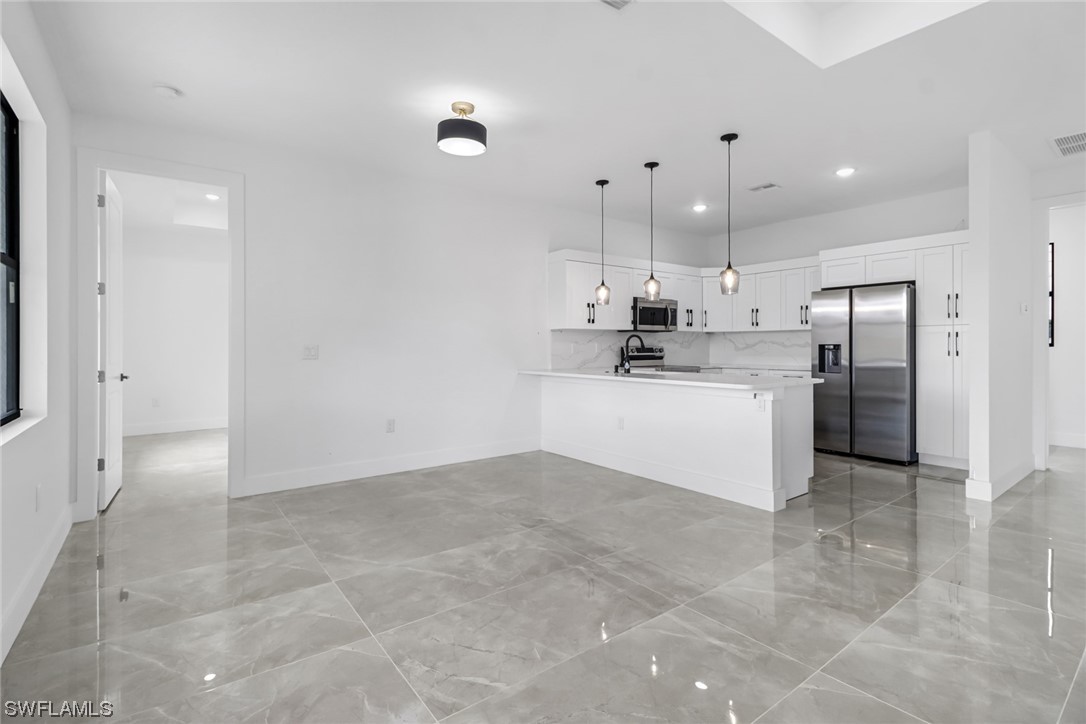 2607 4th Street Southwest Lehigh Acres, FL 33976 - Photo 11 of 21 a large kitchen with cabinets and stainless steel appliances