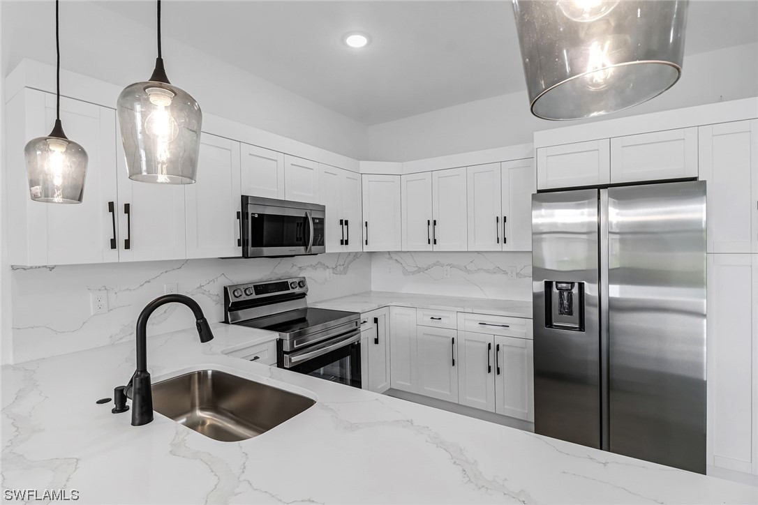 2607 4th Street Southwest Lehigh Acres, FL 33976 - Photo 2 of 21 a kitchen with stainless steel appliances granite countertop a sink stove and refrigerator