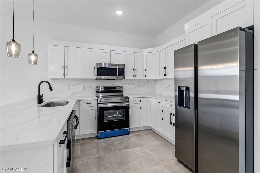 2607 4th Street Southwest Lehigh Acres, FL 33976 - Photo 3 of 21 a kitchen with stainless steel appliances a refrigerator sink and stove