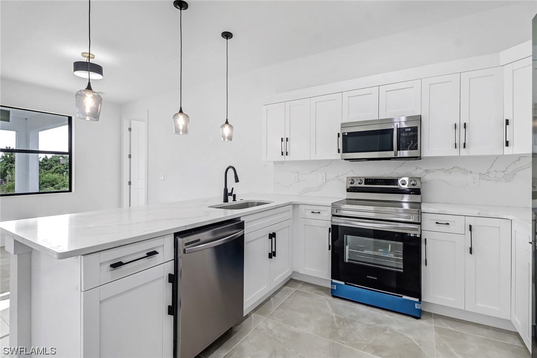 2607 4th Street Southwest Lehigh Acres, FL 33976 - Photo 4 of 21 a kitchen with appliances a sink and cabinets