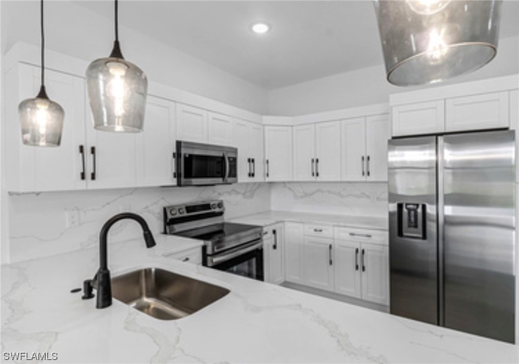 2607 4th Street Southwest Lehigh Acres, FL 33976 - Photo 6 of 21 a kitchen with stainless steel appliances granite countertop a sink a stove and a refrigerator