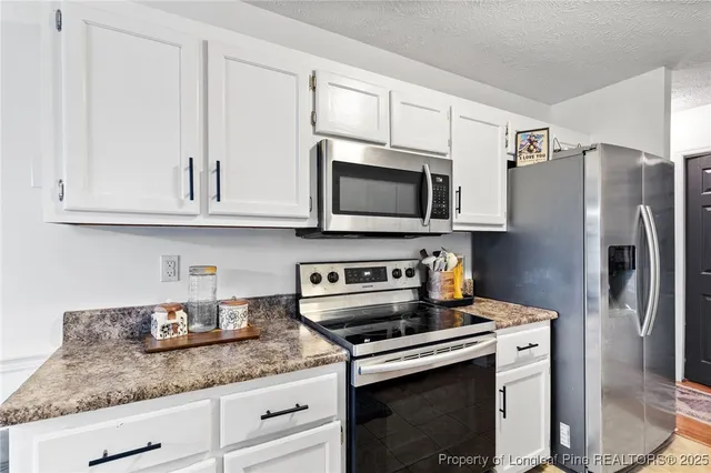 a kitchen with stainless steel appliances granite countertop a refrigerator sink and stove