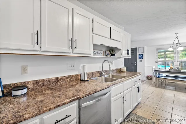 a kitchen with granite countertop a sink and cabinets