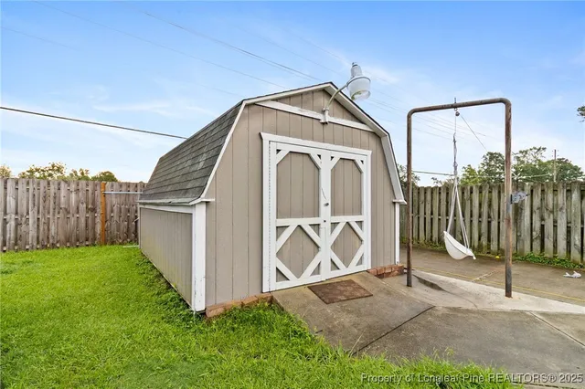 a view of a house with a small yard and wooden fence