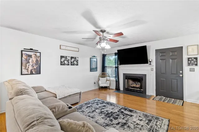 a living room with furniture a flat screen tv and a fireplace