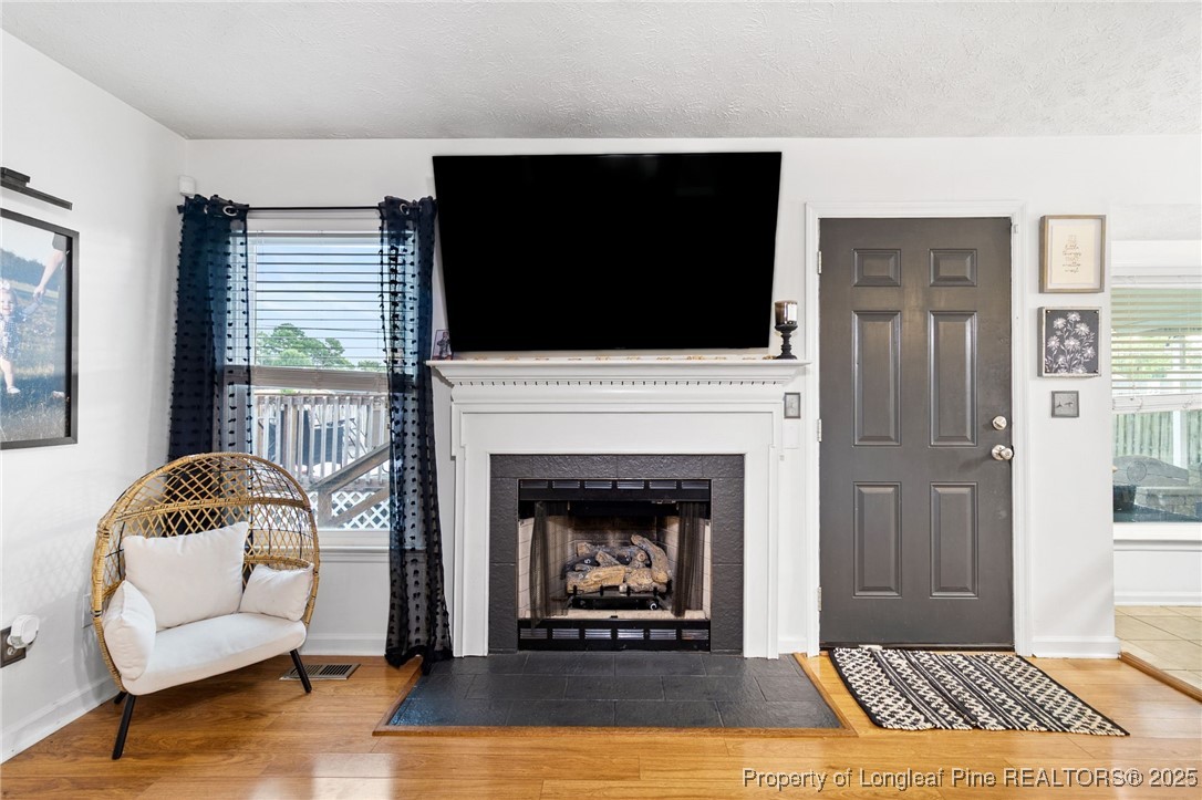 4213 Buckhurst Drive Hope Mills, NC 28348 - Photo 5 of 27 a living room with furniture a flat screen tv and a fireplace