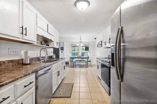a kitchen with granite countertop a sink stainless steel appliances and cabinets
