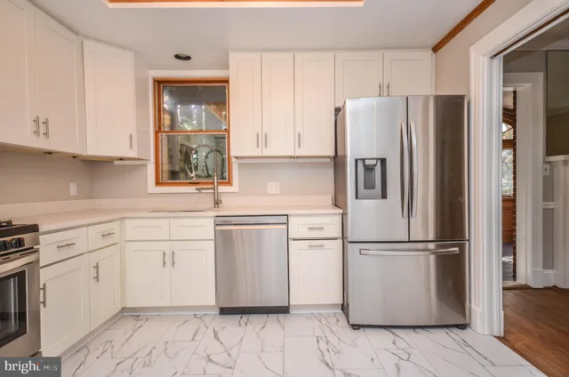 a kitchen with white cabinets and appliances