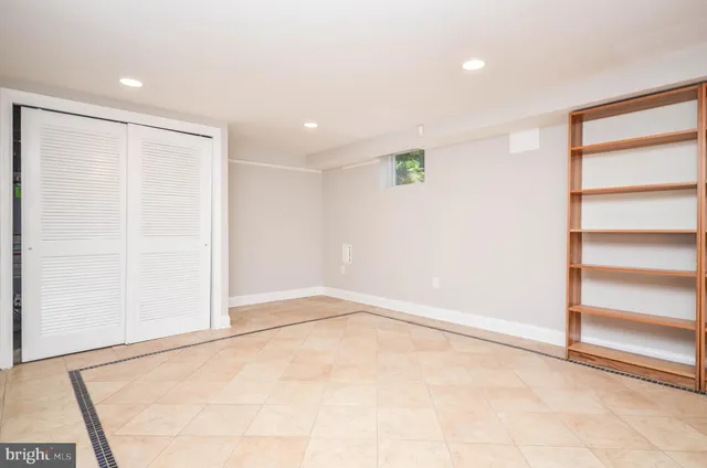 an empty room with wooden floor and stairs