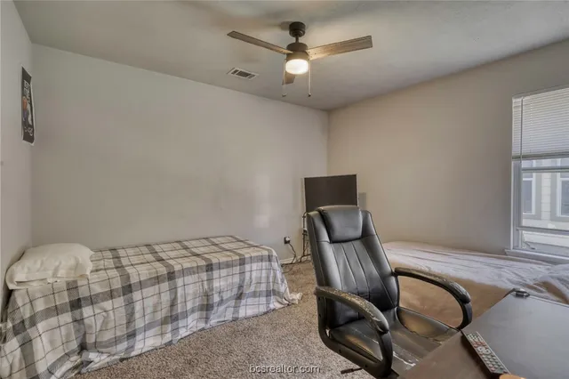 a bedroom with a bed chair and a window
