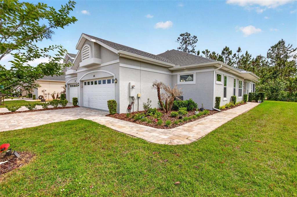 66 Wrendale Loop Ormond Beach, FL 32174 - Photo 61 of 88 a view of a white house with a big yard and potted plants