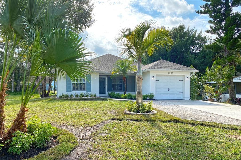 3285 3rd Place Vero Beach, FL 32968 - Photo 2 of 34 a front view of a house with a yard garage and outdoor seating