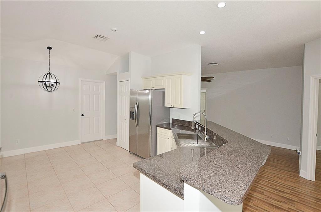 3285 3rd Place Vero Beach, FL 32968 - Photo 13 of 34 a kitchen with stainless steel appliances granite countertop a refrigerator and a sink
