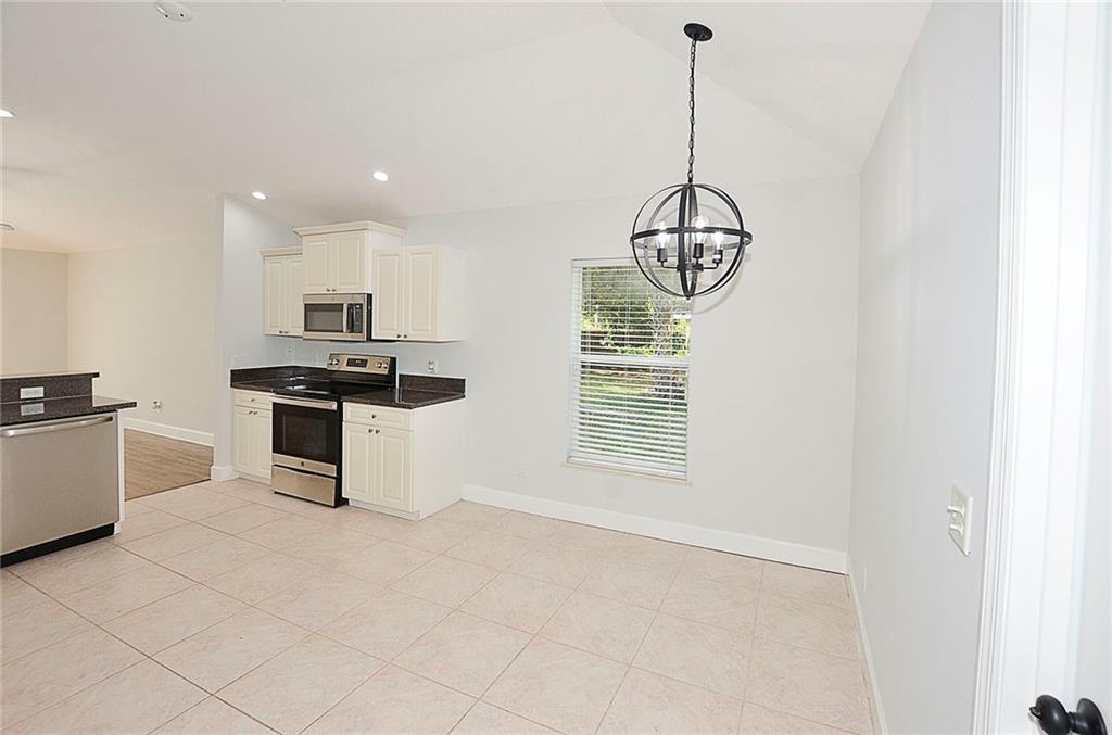 3285 3rd Place Vero Beach, FL 32968 - Photo 18 of 34 a kitchen with stainless steel appliances granite countertop a stove a sink and a microwave