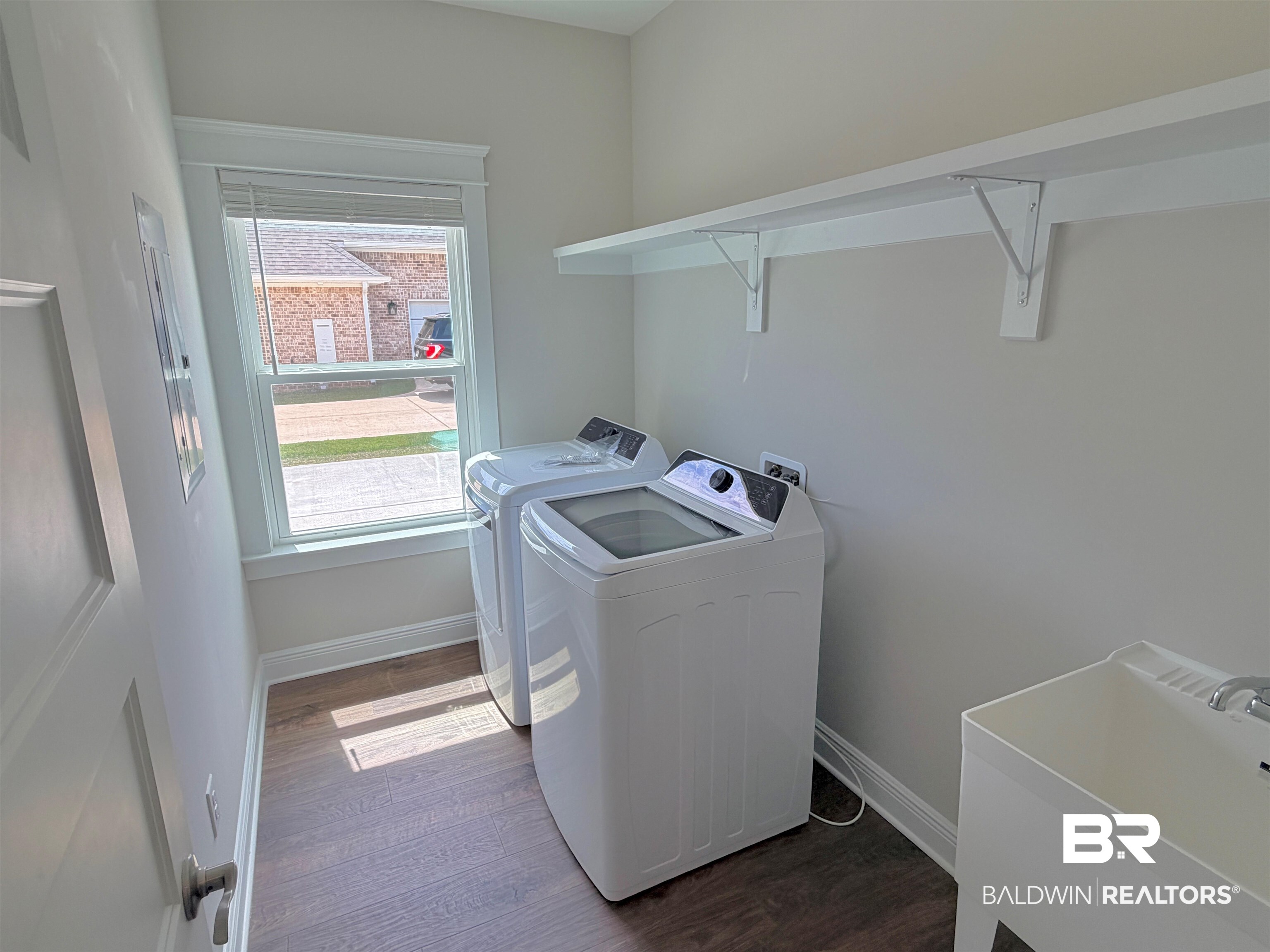 318 Morning Mist Way Fairhope, AL 36532 - Photo 10 of 20 Utility room featuring wood-finish flooring, a single window with blinds, and white wall shelving
