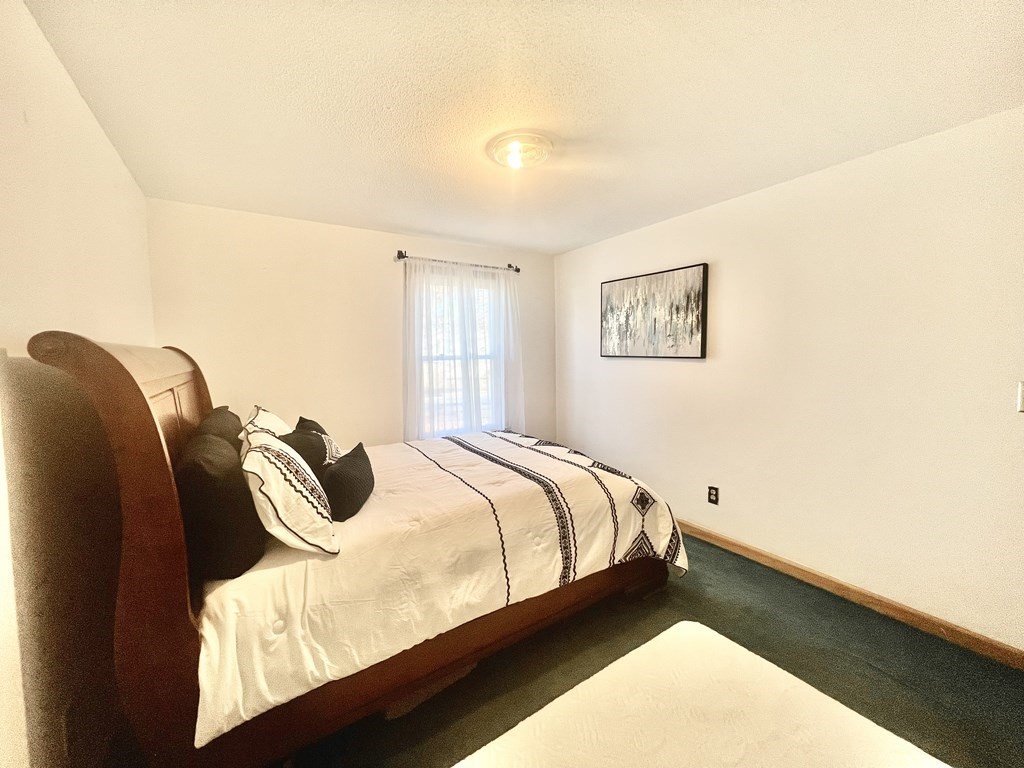 140 Ellendale Circle Springfield, MA 01128 - Photo 13 of 21 a bed sitting in a bedroom next to a window with wooden floor